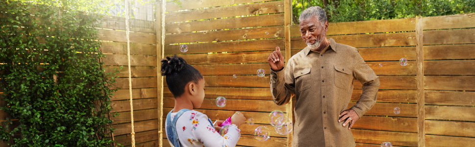 Grandfather and granddaughter blowing bubbles